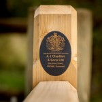 Logo of A J Charlton & sons with royal appointment seal shown on a wooden gate