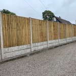 Image of double gravel boards under a panel fence in between concrete posts on a flat piece of ground