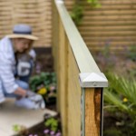 DuraPost Olive Grey capping rail shown on top of a wooden fence