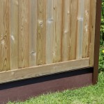 DuraPost gravel board in Sepia Brown shown on the bottom of a wooden fence