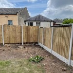 This Concrete fence post is designed to slot panel fencing into. This image shows a panel fence with concrete posts