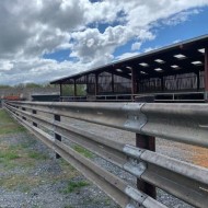 Used crash barriers on a fence with creosote posts