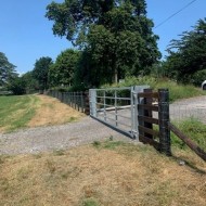 Creosoted stobs and post shown with a galvanised gate
