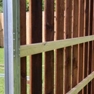 A DuraPost galvanised post shown with wooden rails and pickets attached