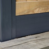 DuraPost Anthracite Grey composite gravel board shown on the bottom of a fence