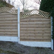 Image of gravel boards under a panel fence set between concrete posts on a sloping hill