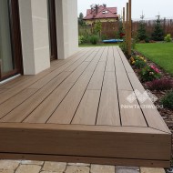 Newtechwood Ultrashield decking boards shown in a garden with a Warm Chestnut colour